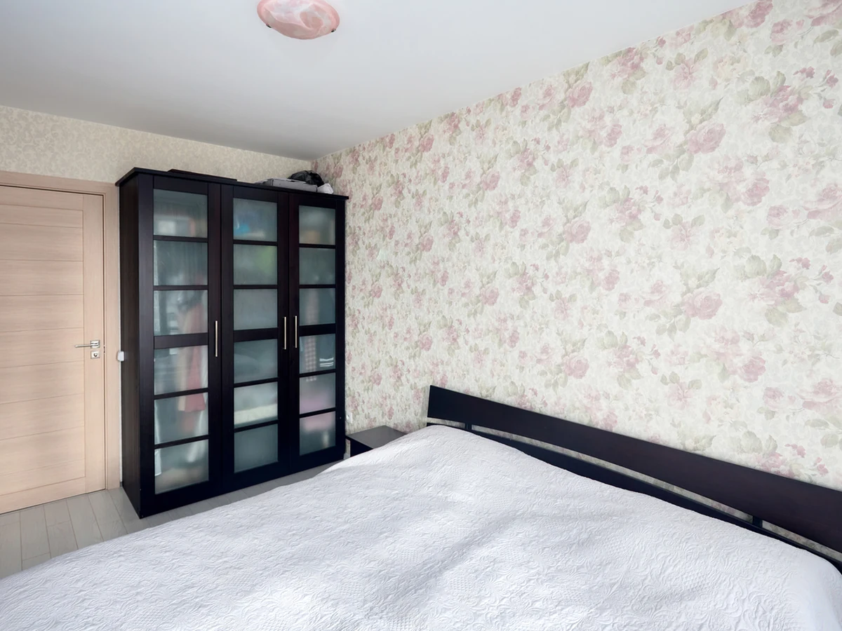 Small bedroom with floral wallpaper installed by Cambridge Decorators, neat finish throughout