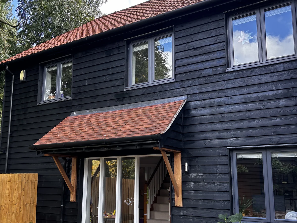 Exterior painting in Cambridge — black cladding house with repainted front entrance — Cambridge Decorators