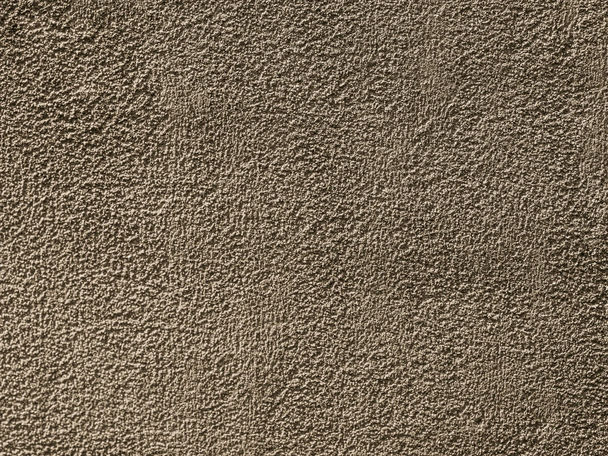 Masonry painting on rough textured exterior wall in Cambridge by Cambridge Decorators