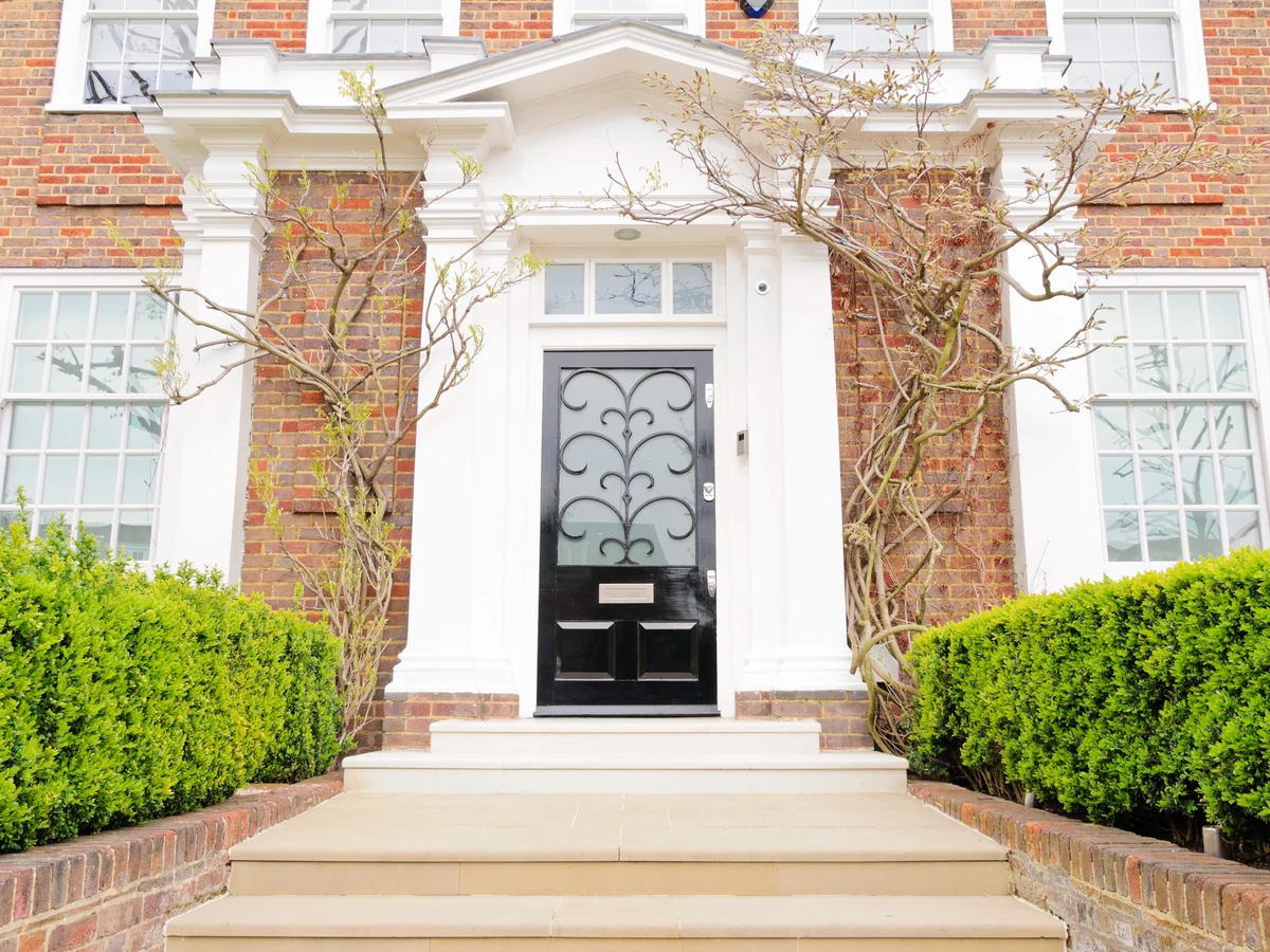 Exterior masonry painting on large red brick house in Cambridge