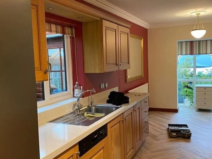 Feature wall painting in progress — red kitchen feature wall, Cambridge — Cambridge Decorators