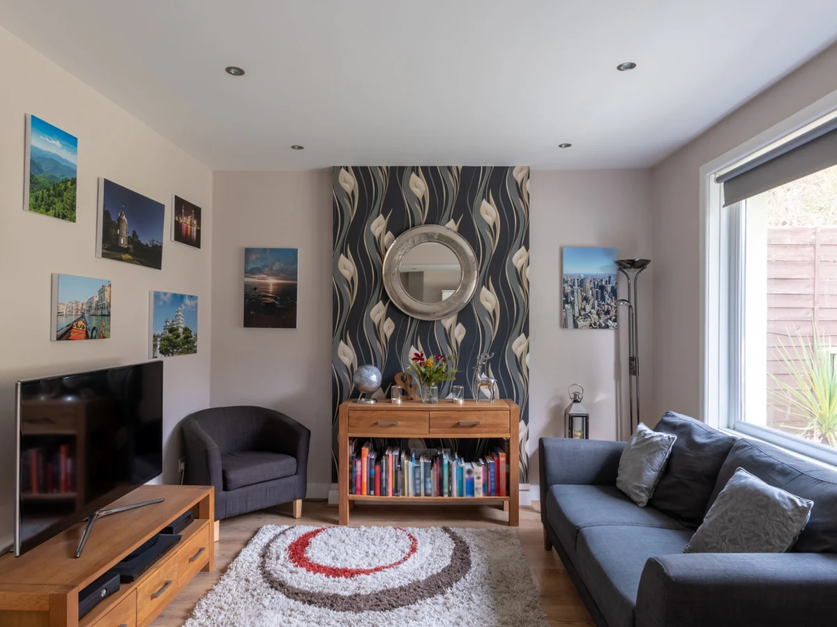 Lounge feature wall with wallpaper installed by Cambridge Decorators, living room transformation