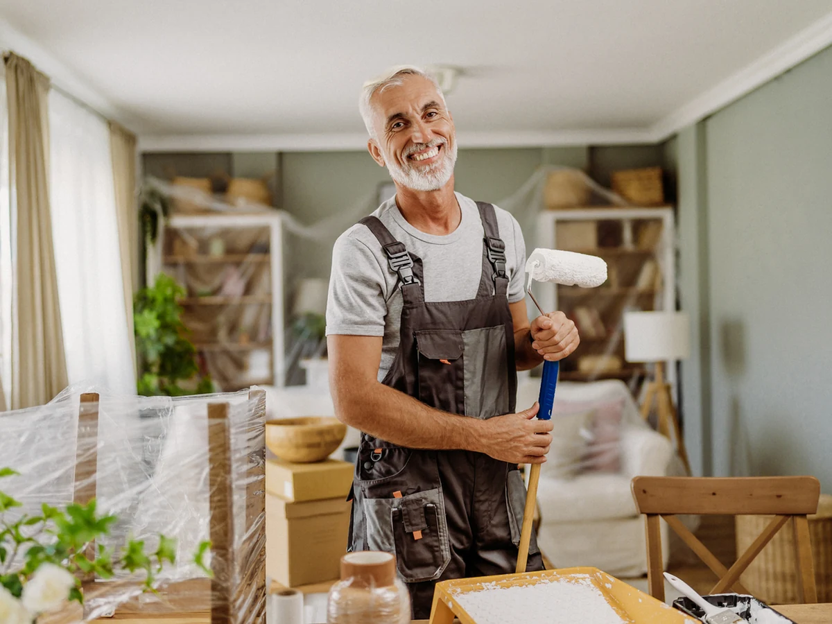 Experienced Cambridge decorator holding painting equipment on a residential project