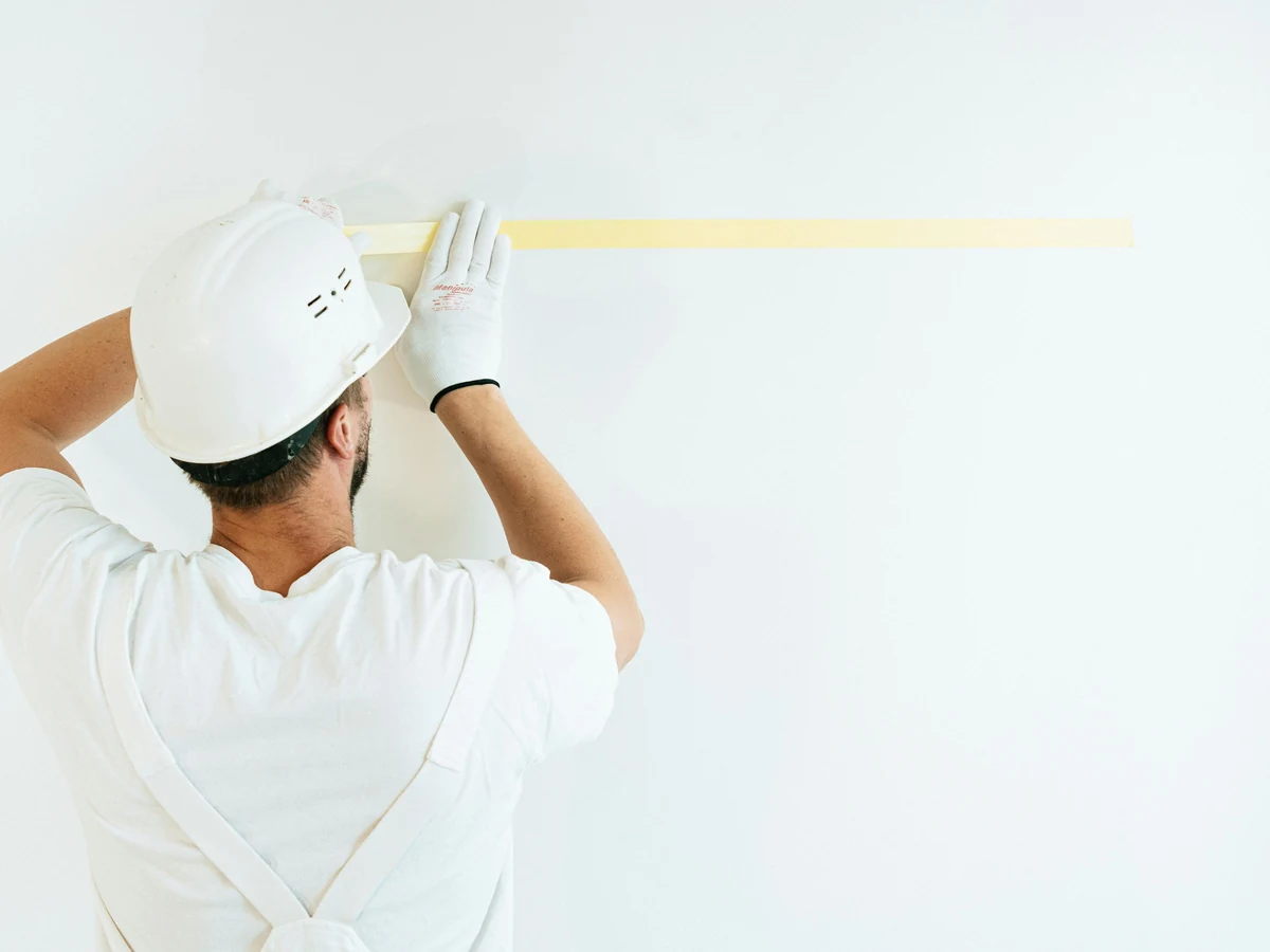 painting-decorating-painter-applying-masking-cambridge-decorators Painter applying masking tape before bathroom painting by Cambridge Decorators